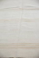 Upcycled hand-woven kilim texture with subtle ivory and silver cool-toned stripes.