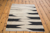 Southwestern hand woven Kilim rug corner, black and beige wavy pattern and delicate fringe.