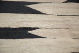 Textured black and beige hand woven Kilim flatweave with jagged geometric bands.