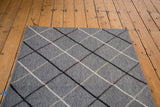 Geometric argyle pattern on new Kilim rug, metal-grey field, neutral lines.