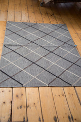 New Kilim rug with metal-grey field and argyle pattern in ivory, beige, black, brown.