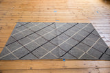 New Kilim rug corner, flat-woven, with metal-grey argyle and ivory, beige, black lines.
