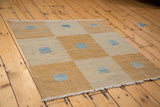 New geometric square-on-square Kilim rug with saffron gold, ivory, and abrash blue.