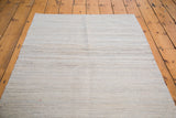 Textured new Kilim rug displaying varying shades of ivory, grey, and silver stripes.