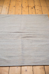 New Kilim rug's flat weave texture with subtle ivory, grey, and silver hues.