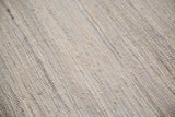 New kilim rug woven texture with varying ivory, grey, and silver tones.