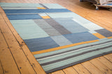 Modern abstract kilim, geometric blocks and striped bands in blue, gray, and saffron gold.