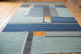 Abstract modern hand-woven kilim showing geometric squares, stripes, in blue, charcoal, saffron.
