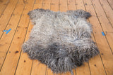 Fluffy angora throw pelt with blended natural gray and charcoal hues.