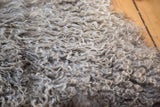 Fluffy, curly grey Angora wool pile texture of a new throw.