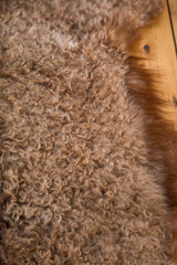 Luxurious Angora wool throw pelt with curly texture and natural brown fur edge.