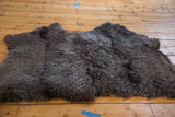 Luxurious dark brown Angora throw, showcasing its dense, curly, soft wool.