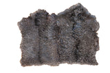 Dark grey angora throw rug with a luxurious, curly wool texture.