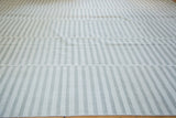 Horizontal joining bands separating light ivory and gray striped Kilim panels.