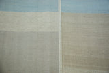 Kilim carpet section with horizontal light blue, ivory, grey blocks and vertical decorative seam.