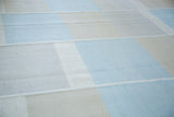 Decorative parallel seaming separating light blue, ivory, and beige wool blocks.