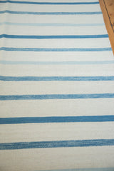 Contemporary hand-woven Kilim carpet with soft blue and white stripe texture.