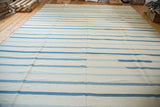 Contemporary hand woven Kilim carpet featuring varied soft blue and white stripes.