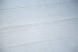 Hand-seamed platinum white hemp kilim texture with subtle silver and grey tones.