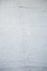 Hand-woven hemp Kilim texture, central hand-seam, iridescent platinum white with silver-grey.