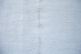 Hand-seamed join of the vintage hemp kilim, showcasing its flat-woven platinum white texture.