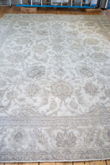 Distressed vintage Sivas rug border showcasing beige curvilinear patterns.