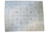 Distressed vintage Sivas carpet, sprawling palmette motifs on a stark white field, silver and beige.