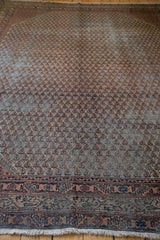 Faded blue and red Mir Serbend pattern and traditional border detail on distressed vintage rug.