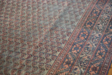 Distressed Mir Serbend rug detail, showing faded blue and light red field pattern and border.
