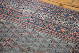 Mir Serbend carpet's distressed pile showing faded light red and blue geometric motifs.