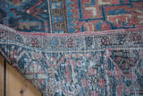 Distressed low pile and exposed foundation of a vintage Heriz rug in rose and charcoal blue.