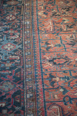 Low pile Heriz carpet with compartmentalized geometric patterns in rose and charcoal blue.