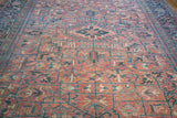 Vintage Heriz rug's allover geometric pattern, low pile, and subtle rose and charcoal blue.