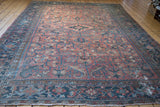 Distressed pile and softened rose, charcoal blue tones of a vintage Heriz rug.