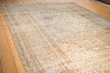 Intricate bronze, gold, and beige pattern on a distressed Khorossan carpet's textured pile.