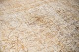 Distressed Khorossan carpet's intricate pattern and visible foundation texture in bronze and gold.