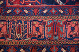 Dense pile of vintage Joshegan rug, showing stylized geometric motifs in indigo, coral, and aqua.