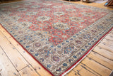 Vintage Birjand carpet corner, highlighting aqua blue floral motifs on beige border.