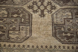 Detail of geometric foliage and guls in charcoal and grey on the camel-colored wool pile.