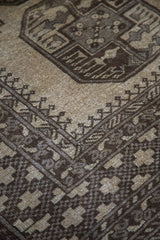 Detailed view of a geometric gul in charcoal and grey on the camel hand-knotted pile.