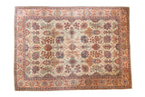 Distressed Kazvin carpet with Safavid palmettes and floral vines in ruby, emerald, navy, and beige.
