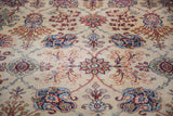Distressed Kazvin carpet close-up: intricate palmettes, lotus flowers, scrolling vines in jewel tones.