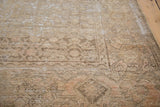 Distressed vintage Malayer rug corner, highlighting sandy bronze tones and faded geometric pattern.