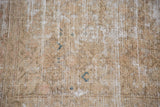 Distressed pile texture of a vintage Malayer rug showcasing sandy bronze and light tones.
