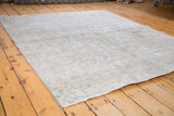Distressed Tabriz rug with blanched fade showing worn texture and subtle pattern.