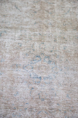 Intricate weave of a vintage distressed Tabriz rug showing blanched beige and faint blue design.
