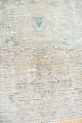 Intricate patterns and sun-kissed fade on a distressed Tabriz rug fragment.