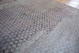 Close-up of the distressed Oushak runner's textured harlequin pattern in neutral beige and mauve.