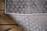 Hand-knotted foundation and distressed harlequin design on a vintage Oushak runner.