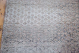 Distressed Oushak runner with textured harlequin pattern in muted grey and beige.
